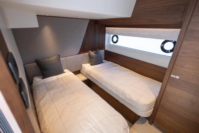 Luxurious twin cabin interior on 2023 Princess S72 yacht, featuring modern design and wood accents.