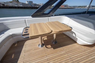 Luxurious 2023 Princess S72 yacht deck with wooden table and white seating.