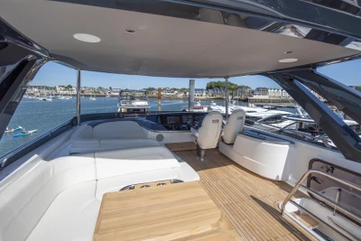 Luxurious 2023 Princess S72 yacht interior with elegant seating and scenic marina view.