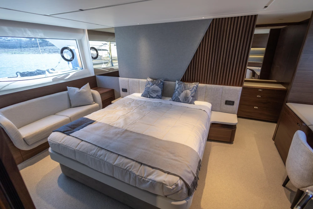 Luxurious 2023 Princess S72 yacht bedroom with elegant decor and scenic window views.