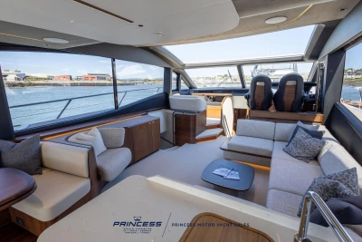 Luxurious interior of 2023 Princess S72 yacht with modern seating and panoramic windows.