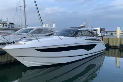2017 Princess V40 yacht docked at marina, sleek design, calm water reflection.