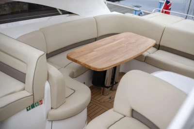 Luxurious seating area on a 2006 Princess V48 yacht with wooden table.