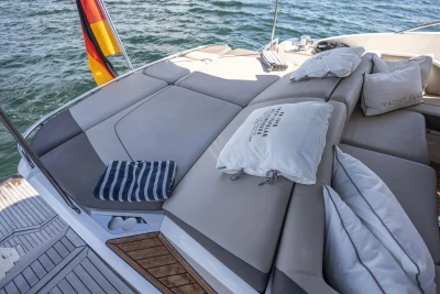 Luxurious sunbed on 2014 Princess S72 yacht with cushions and German flag, overlooking the sea.