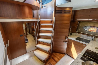 Luxurious interior of 2014 Princess S72 yacht featuring elegant wood finishes and modern kitchen.