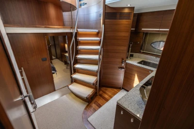 Luxurious interior of 2014 Princess S72 yacht featuring elegant wood finishes and modern kitchen.