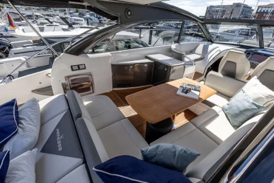 Luxurious interior of 2015 Princess V48 Open yacht with elegant seating and wooden table.