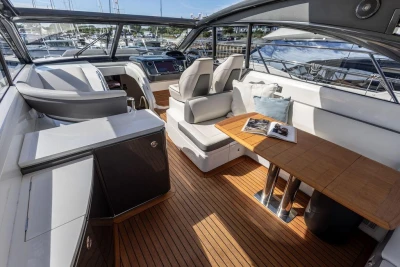 Luxurious interior of 2015 Princess V48 Open yacht with elegant seating and wooden table.