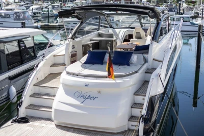 Luxurious 2015 Princess V48 Open yacht docked at marina, featuring elegant seating and sleek design.