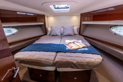 Luxurious cabin interior of 2015 Princess V48 Open yacht with cozy bedding and skylight.