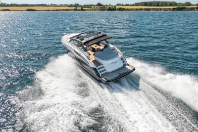 2015 Princess V48 Open yacht cruising on a sunny day, creating waves in the water.