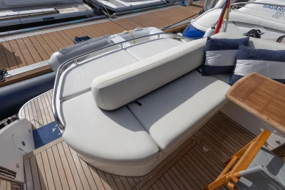 Luxury seating area on 2015 Princess V39 yacht with striped cushions and wooden deck.