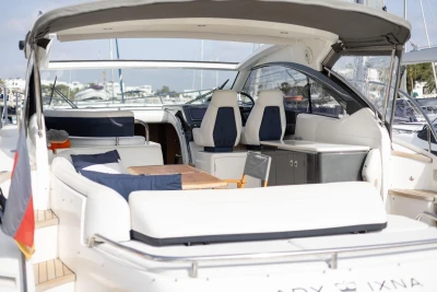 Luxurious 2015 Princess V39 yacht interior with seating and helm, docked at marina.
