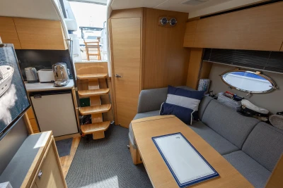 Luxurious interior of 2015 Princess V39 yacht with modern kitchen and cozy seating area.