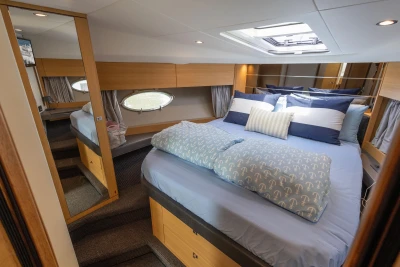 Luxurious cabin interior of 2015 Princess V39 yacht with elegant bedding and modern design.