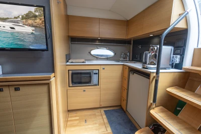 Modern kitchen interior of 2015 Princess V39 yacht with appliances and wooden cabinetry.