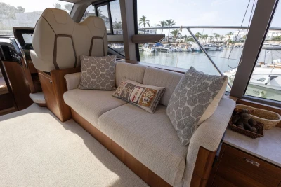 Luxurious interior of 2024 Princess F50 yacht with elegant sofa and scenic marina view.