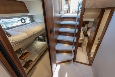 Luxurious interior of 2024 Princess F50 yacht with cozy bunk beds and elegant staircase.