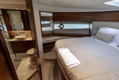 Luxurious 2024 Princess F50 yacht bedroom with ensuite bathroom and elegant wood finishes.