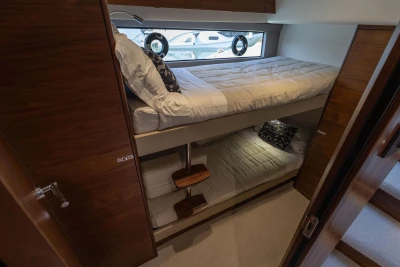 2024 Princess F50 yacht interior with cozy bunk beds and elegant wood finish.