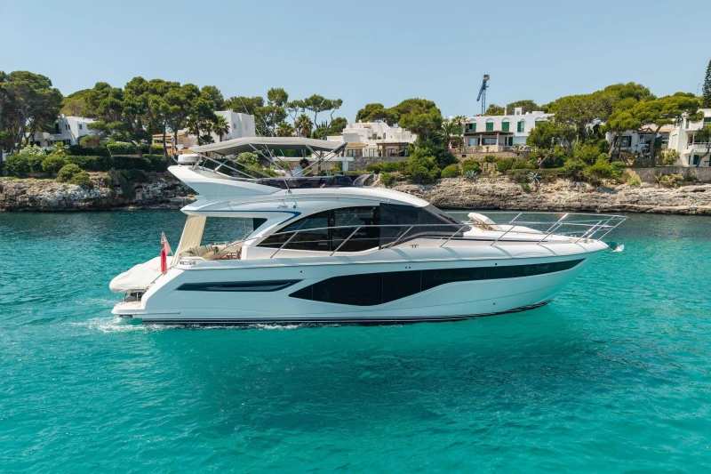 2024 Princess F50 yacht cruising on turquoise waters near a scenic coastline.