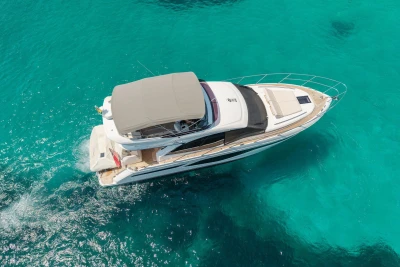 2024 Princess F50 yacht cruising on clear turquoise waters, aerial view.