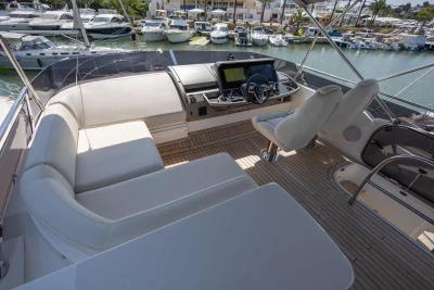 Luxurious 2024 Princess F50 yacht interior with helm and seating area in marina setting.