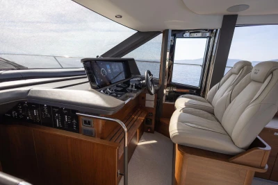 Luxurious interior of 2025 Princess F65 yacht with modern helm and plush seating.
