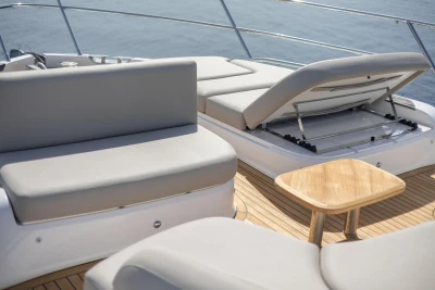 Luxurious 2025 Princess F65 yacht deck with cushioned seating and wooden table.