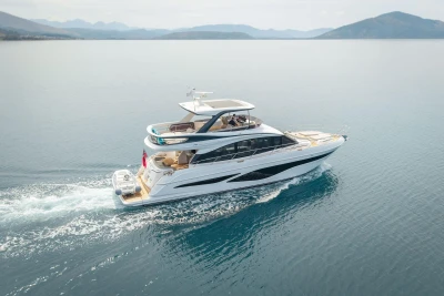 Luxurious 2025 Princess F65 yacht cruising on serene waters with scenic mountain backdrop.