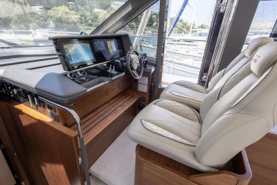 Luxurious helm of 2025 Princess F65 yacht with advanced navigation displays and plush seating.