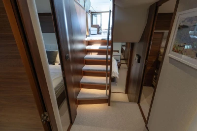 Luxurious interior of 2025 Princess F65 yacht with elegant wooden staircase and modern design.