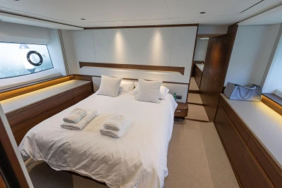 Luxurious bedroom interior of 2025 Princess F65 yacht with elegant wood finishes.