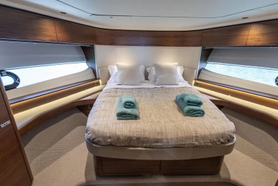 Luxurious bedroom interior of 2025 Princess F65 yacht with elegant wood finishes.