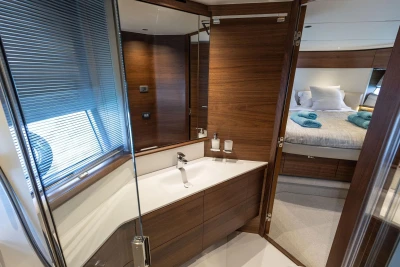 Luxurious bathroom and bedroom interior of 2025 Princess F65 yacht, featuring elegant wood finishes.