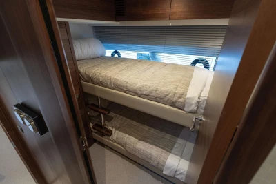 Luxurious 2025 Princess F65 yacht cabin with cozy bunk beds and elegant wood finishes.