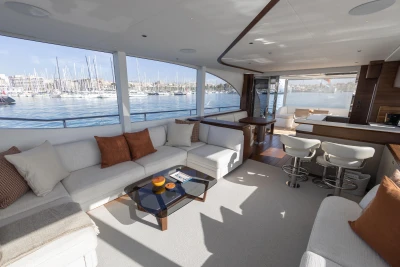 Luxurious interior of 2026 Princess Y72 yacht with marina view, featuring elegant seating and modern design.