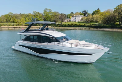 Luxurious 2026 Princess Y72 yacht cruising on a serene river with lush greenery.