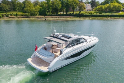 Luxurious 2026 Princess V40 yacht cruising on serene waters near lush green landscape.