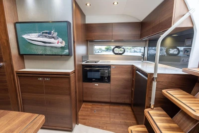 Luxurious interior of 2026 Princess V40 yacht with modern kitchen and wooden finishes.