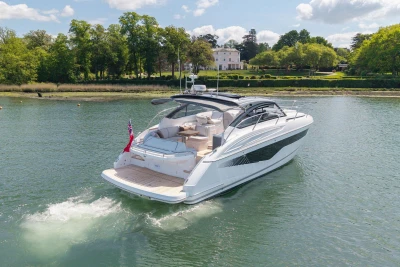 2026 Princess V40 yacht cruising on a serene river with lush greenery.