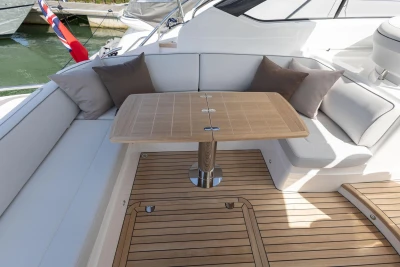 Luxurious seating area on 2026 Princess V40 yacht with wooden table and cushions.