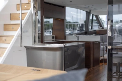 Luxurious interior of 2026 Princess F65 yacht, featuring modern kitchen and elegant wooden staircase.