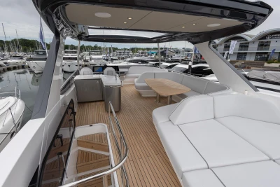 Luxurious 2026 Princess F65 yacht with spacious deck and elegant seating at marina.