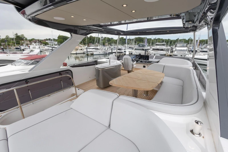Luxurious 2026 Princess F65 yacht interior with elegant seating and dining area at marina.