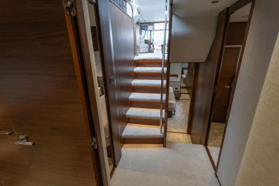 Interior view of 2026 Princess F65 yacht, featuring elegant wooden stairs and modern design.