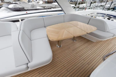 Luxurious seating area on 2026 Princess F65 yacht with wooden table and sleek design.