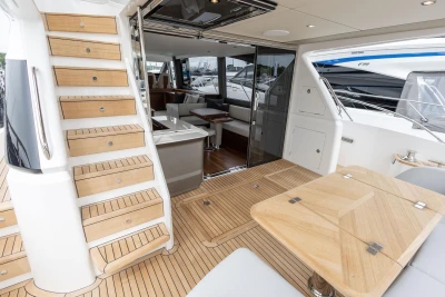 Luxurious 2026 Princess F65 yacht interior with wooden stairs and elegant seating area.
