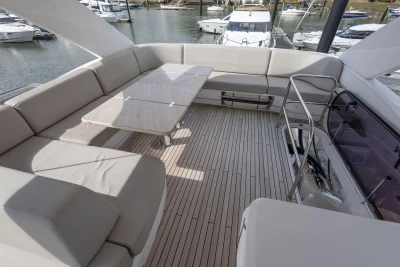 Luxurious 2020 Princess F55 yacht deck with elegant seating and table, docked at marina.