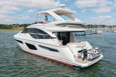 Luxury 2020 Princess F55 yacht cruising in a scenic marina setting.